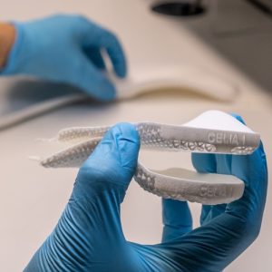Phits custom orthoses being made: hands wearing blue sterile gloves assemble the components of the insole