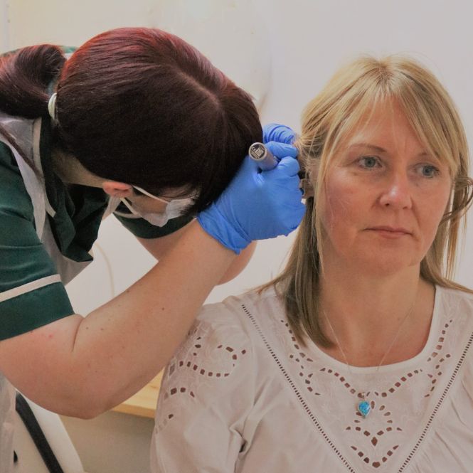 Nurse Anna Blackshaw, part of the integrated whole-person healthcare team at The Lomond Clinic, examines the ear of a female patient