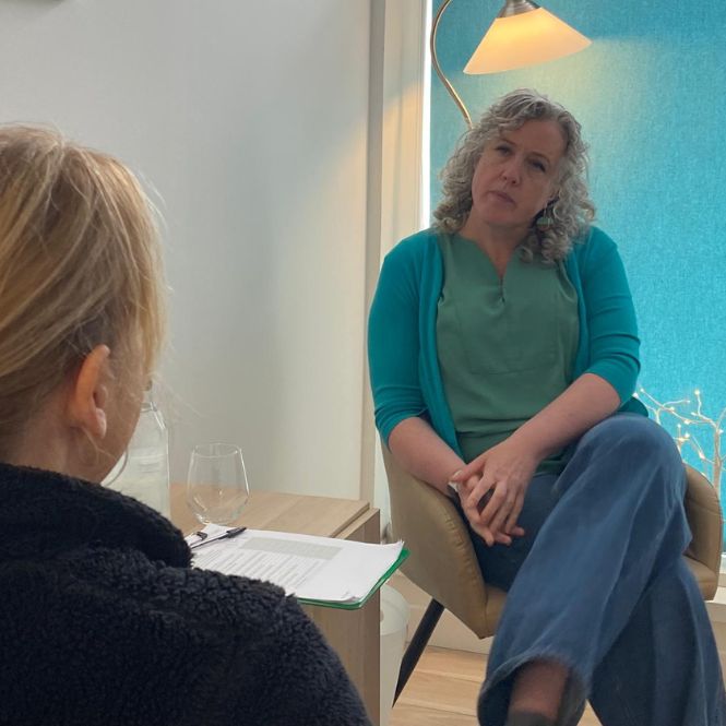 Counsellor Liz Grant, part of the integrated whole-person healthcare team at The Lomond Clinic, sits opposite a female client.