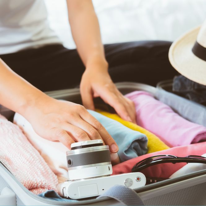 Cropped image of person packing a suitcase for holidays