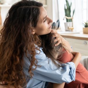 Mother hugs teenage daughter