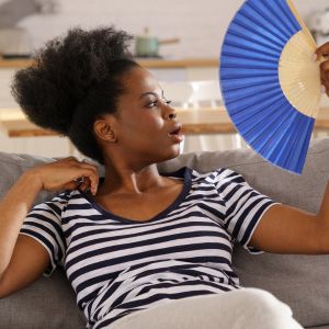 Woman fans herself to cool down