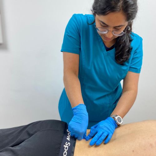 Physiotherapist Sakshi Duseja works on a patient's back as he lies on a tretament table at The Lomond Clinic, Helensburgh